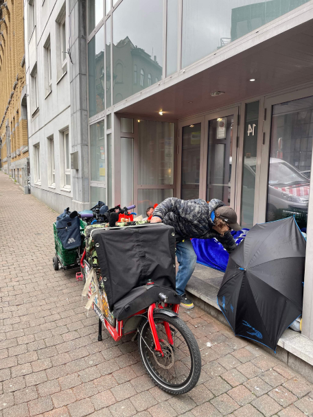 Jean-luc Moerman à vélo offrant un repas à une personne démunie à Bruxelles