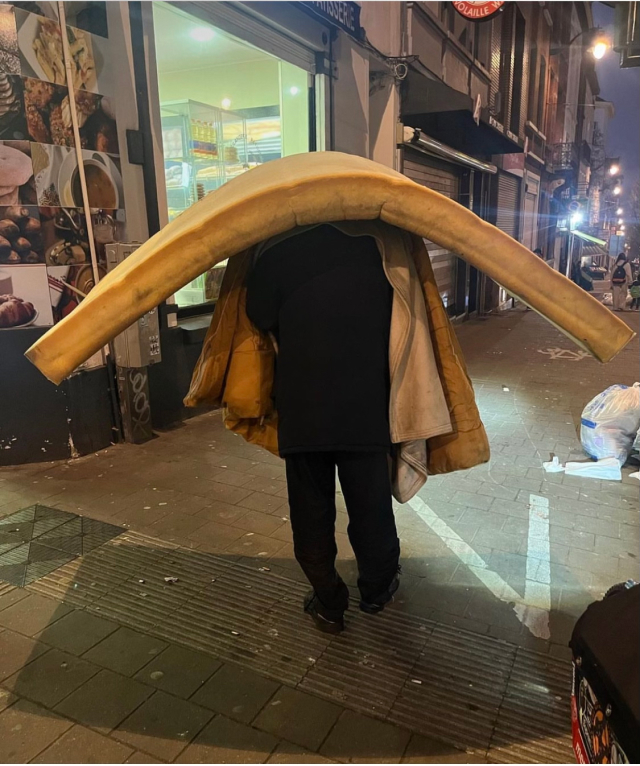 Une personne démunie transportant un matelat à Bruxelles